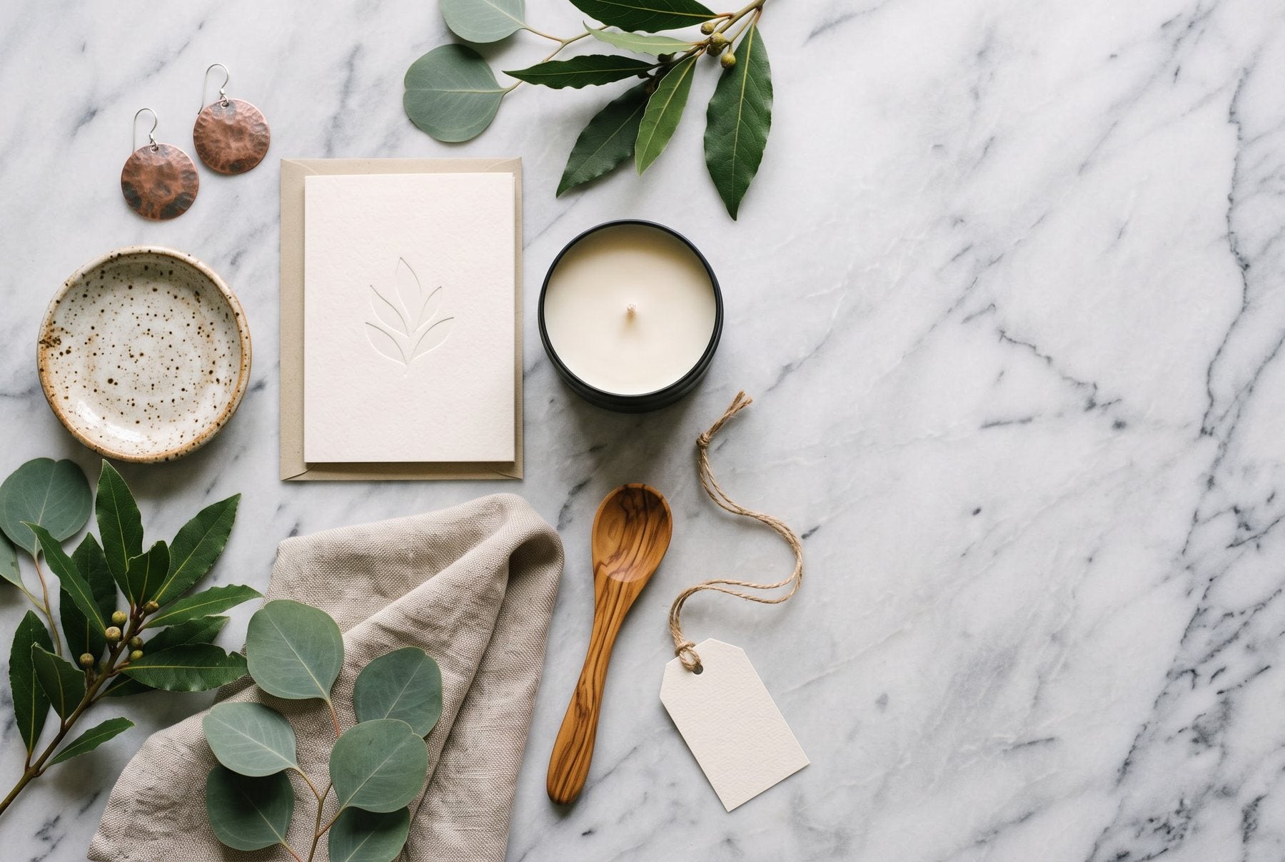 Handmade gifts: a pottery dish, copper earrings, a candle and a carved spoon