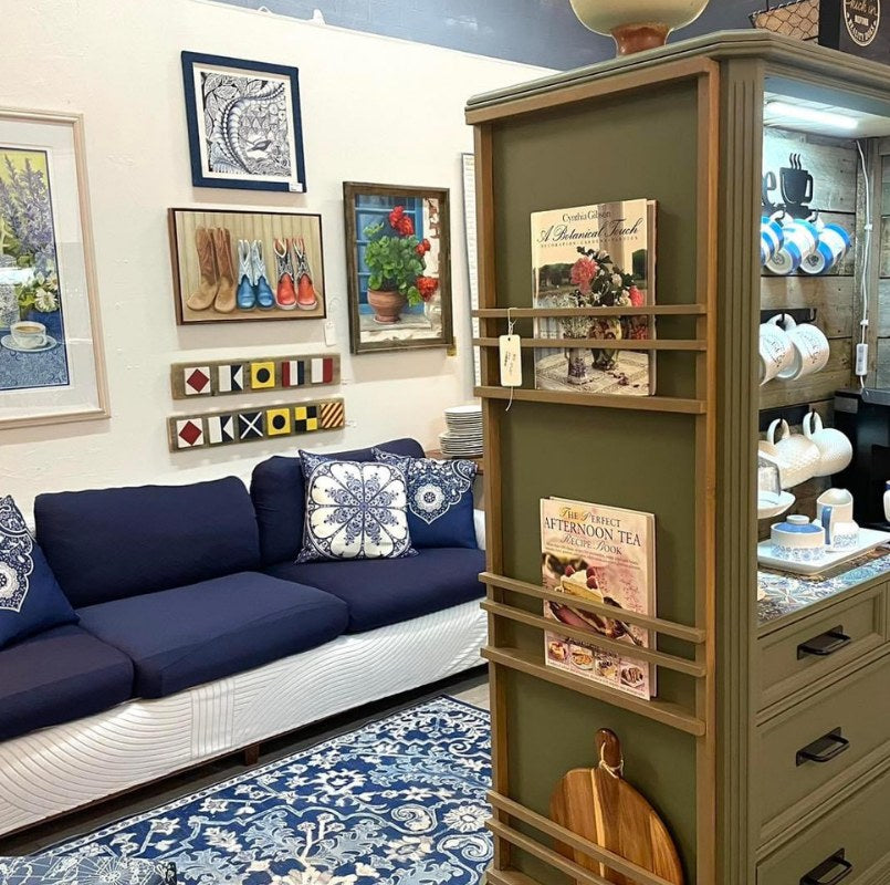 A navy sofa and painted cabinet inside a Local shop